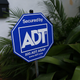 An ADT home security alarm sign is seen in front of a home on February 16, 2016 in Miami, Florida.